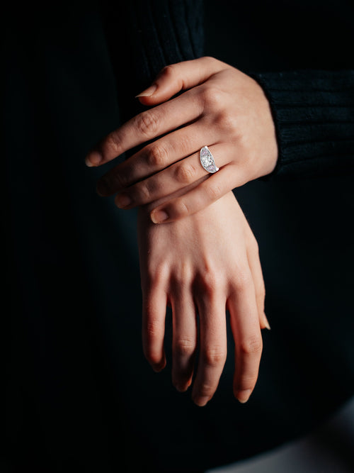 5 stone white diamond engagement ring in rose gold on a ring finger