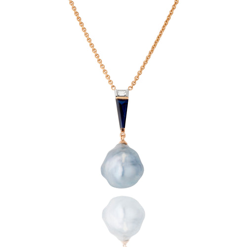 A South Sea pearl pendant with a dark blue tapered baguette cut sapphire and a white tapered baguette cut diamond, suspended from a rose gold chain.