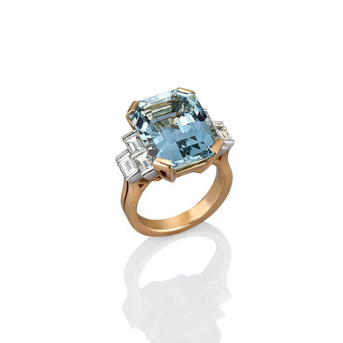 Ring with a large blue aquamarine gemstone and smaller diamonds on a white background