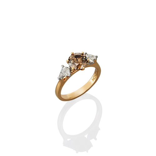 Gold ring with a central argyle champagne diamond stone and smaller white diamonds set on either side.