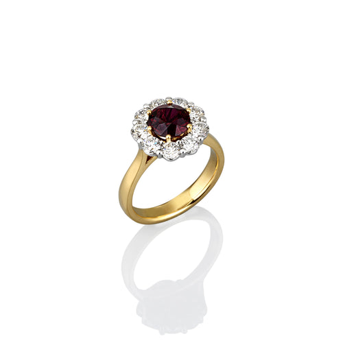 Yellow Gold ring with a ruby gemstone completely encircled by smaller white diamonds