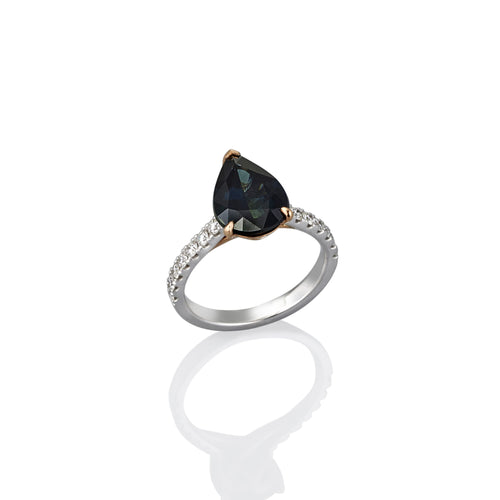 Ring with a black sapphire gemstone and diamond accents along the band, shown here from the side view.