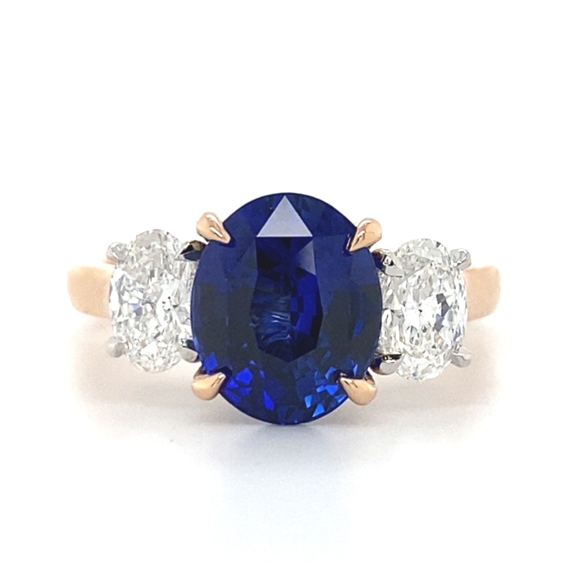 Trilogy oval cut blue sapphire and diamond ring on rose gold band
