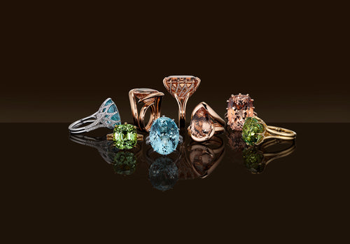 Dress rings with various coloured gemstones on a black background