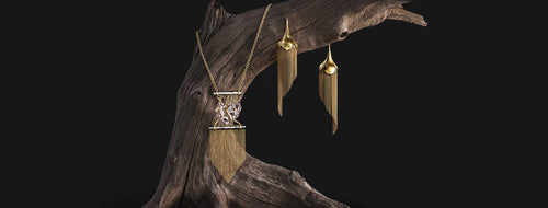 Gold Tassel Earrings and Necklace artfully styled on a wooden branch