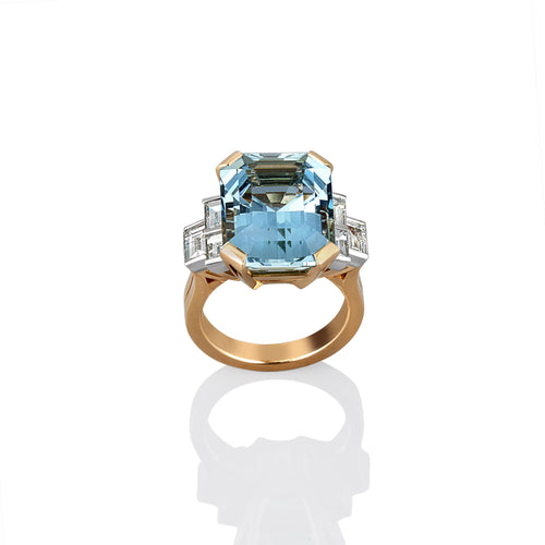 Gold ring with a large blue aquamarine gemstone on a white background