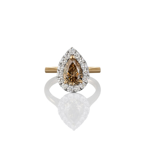 Champagne diamond dress ring with a pear-shaped brown gemstone on a white background