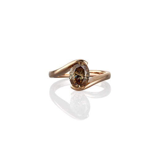 Gold dress ring with a champagne diamond on a white background
