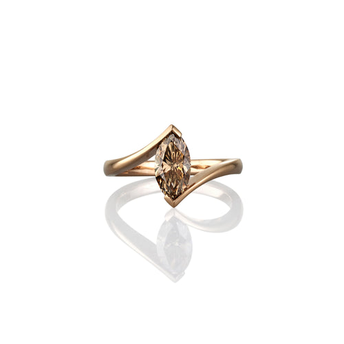 Gold ring with a marquise-shaped brown gemstone on a white background