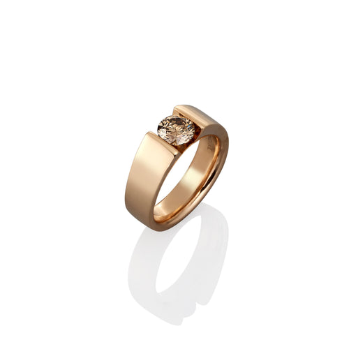 Gold ring with a single champagne diamond on a white background
