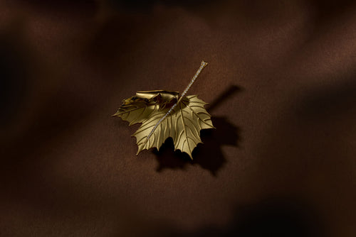 Gold leaf brooch with white diamonds along central vein of the brooch