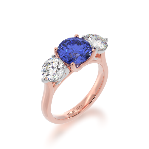 The Mondial by Nadia Round Brilliant cut trilogy blue Sapphire engagement ring with diamonds on rose gold band view from angle.