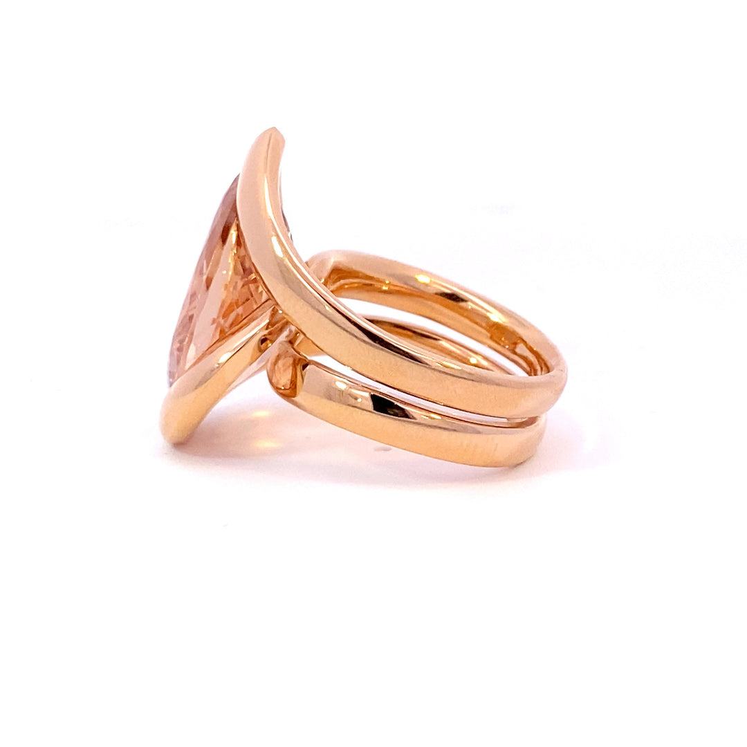 Pear shaped champagne peach coloured morganite ring in infinity design in rose gold view from side 