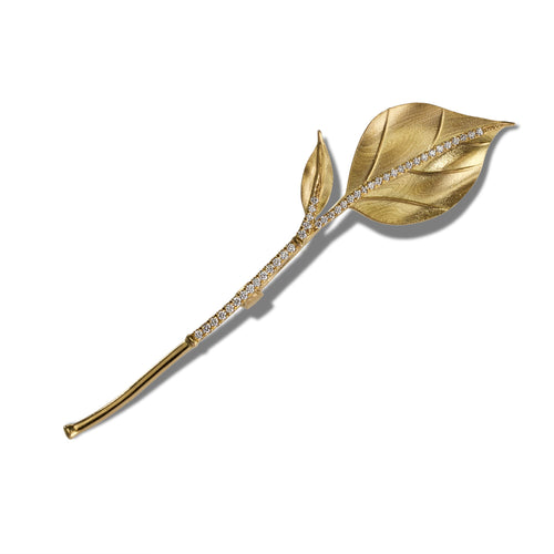 Gold Leaf sprout brooch on a white background.
