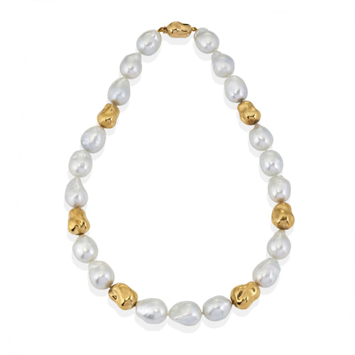 Pearl necklace with gold pearl accents. Photographed on a white background