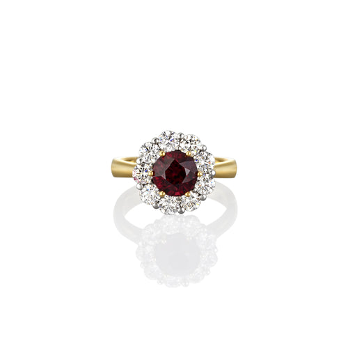Top view of yellow Gold ring with a ruby gemstone completely encircled by smaller white diamonds