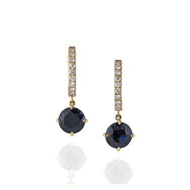 Pair of earrings with blue sapphires and white diamonds with gold accents on a white background
