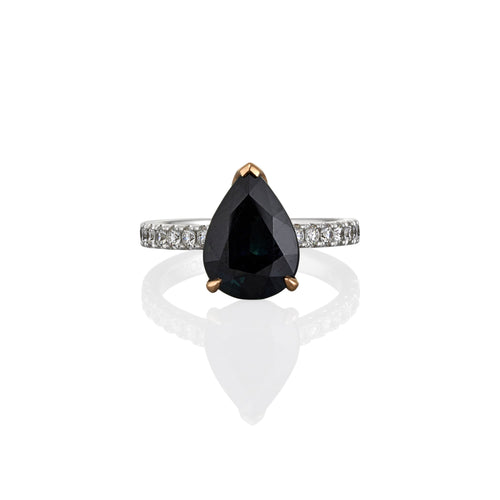 Ring with a black sapphire teardrop-shaped gemstone and white diamond accents on the band