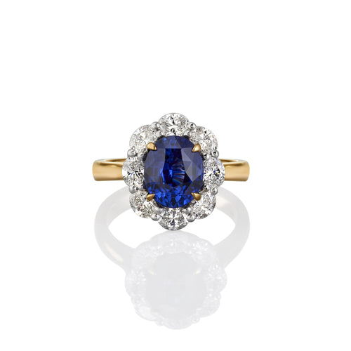 Yellow gold ring with blue sapphire central gemstone and surrounded by white diamonds