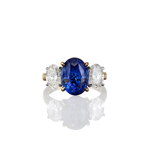 Yellow Gold dress ring with central oval shaped blue sapphire flanked on either side with oval shaped white diamonds
