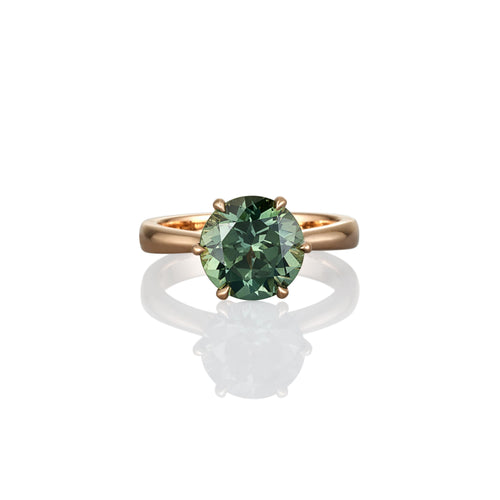 Gold ring with a green gemstone on a white background