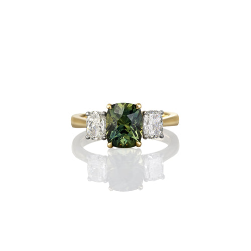 Yellow gold ring with a green gemstone and two smaller diamonds on a white background