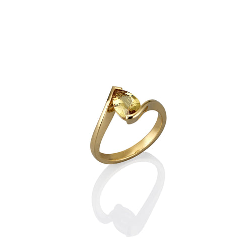 Gold ring with a yellow gemstone on a white background