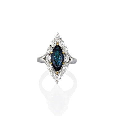 Ring with blue gemstone and diamond accents on a white background