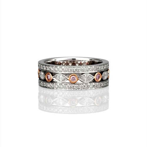 Photographed from the front a wide banded white gold diamond ring consisting of white diamonds and argyle pink diamonds