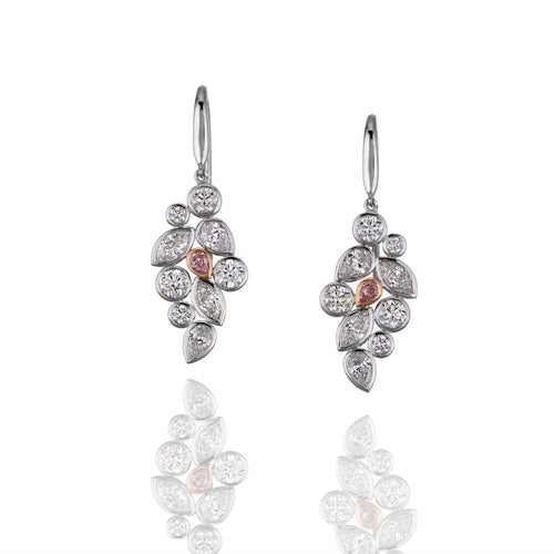 Pair of diamond earrings with rose gold accents on a white background