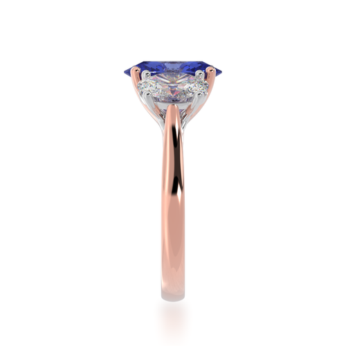 The Mondial by Nadia Trilogy oval cut blue sapphire engagement ring with diamonds on rose gold band view from side.