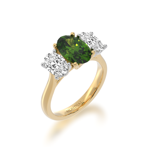 Trilogy oval diamond ring with a green sapphire on a yellow gold band view from angle.