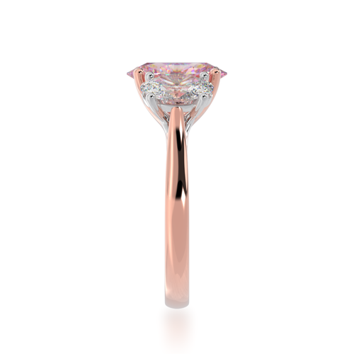 Trilogy oval cut pink sapphire and diamond ring on rose gold band view from side.