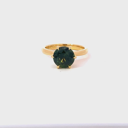 Round brilliant cut green sapphire ring on yellow gold band