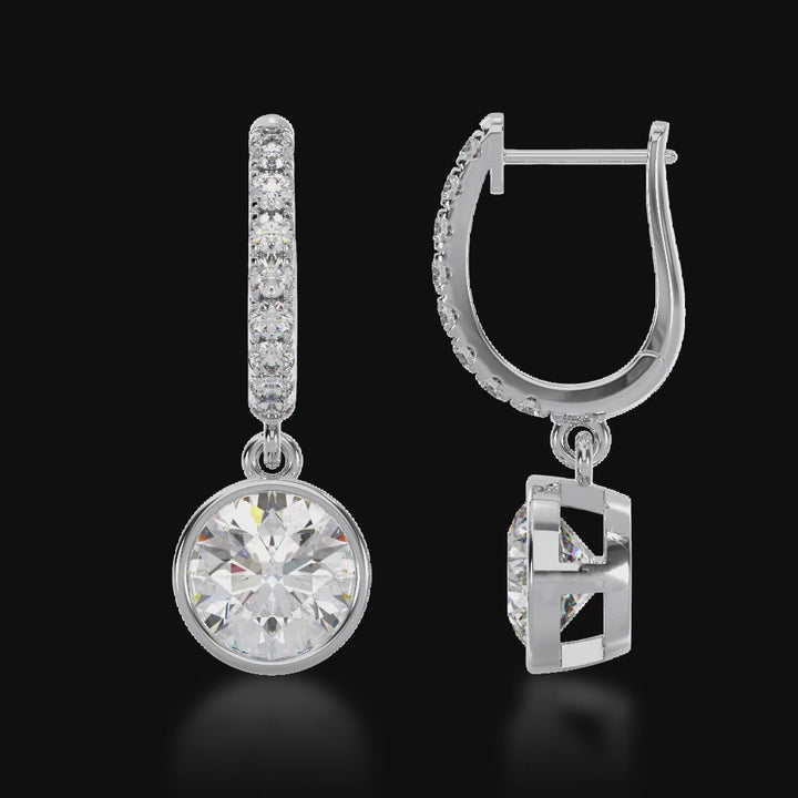 Round brilliant cut bezel set diamond drop earrings on a diamond set huggie 3d video