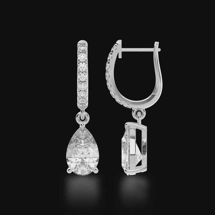 Pear shape diamond drop earrings on a diamond set huggie