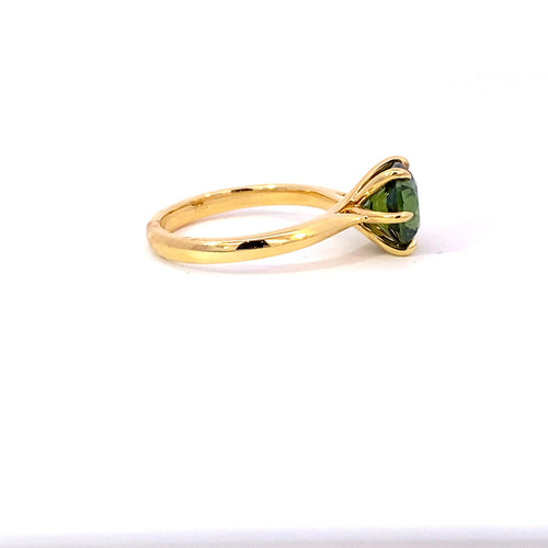 Round brilliant cut green sapphire ring on yellow gold band