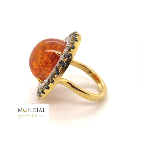 Side view of the Mondial by Nadia oval cabochon Spessartite garnet, sapphire and diamond halo engagement ring on yellow gold band.