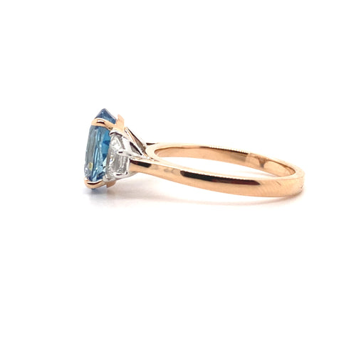 Side view of the Trilogy oval cut aquamarine and diamond ring on rose gold band by Mondial by Nadia.