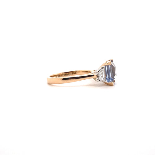 Side view of the Trilogy square cut blue sapphire engagement ring with diamonds on rose gold band by Mondial by Nadia.