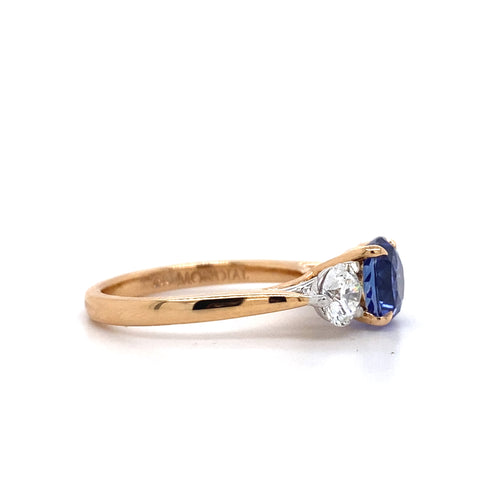 Side view of the Trilogy round brilliant cut blue sapphire engagement ring with diamonds on rose gold band by Mondial by Nadia.