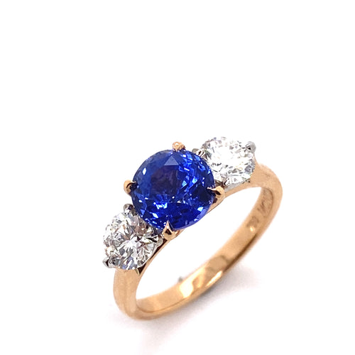 Side top view of the Trilogy round brilliant cut blue sapphire engagement ring with diamonds on rose gold band by Mondial by Nadia.