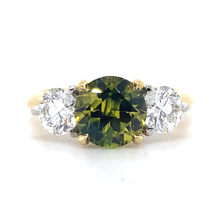 Trilogy round brilliant cut green parti sapphire and diamond ring on yellow gold band