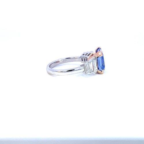 Side view of the Manhattan design radiant cut sapphire and diamond ring on white gold band engagement ring by Mondial by Nadia on a white background.