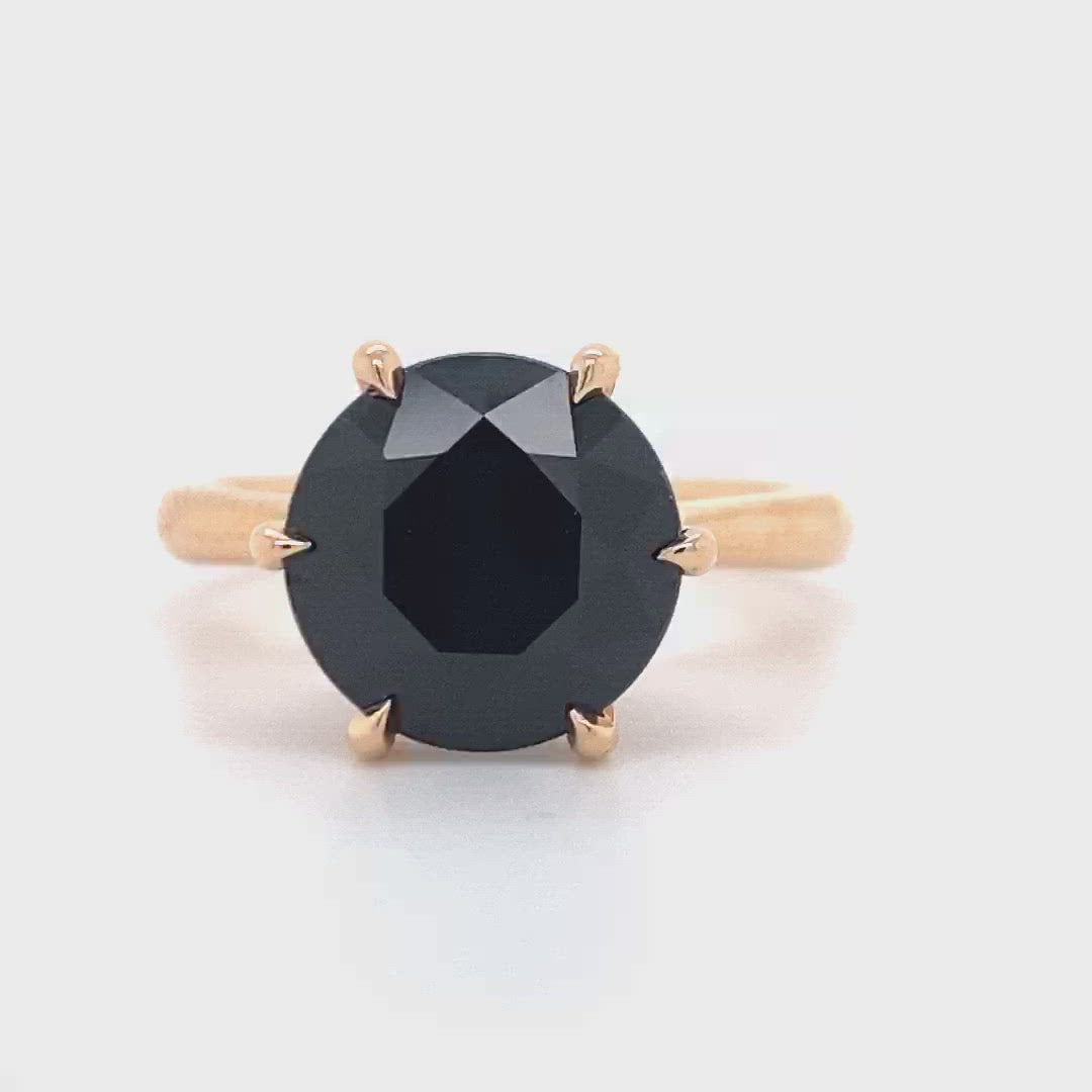 Round brilliant cut black sapphire solitaire ring on rose gold band