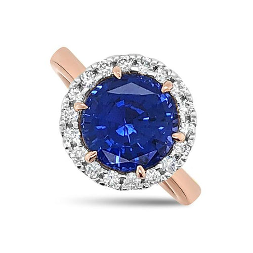 The Round brilliant cut blue sapphire engagement ring with a diamond halo ring on rose gold band engagement ring on a white background by Mondial by Nadia.